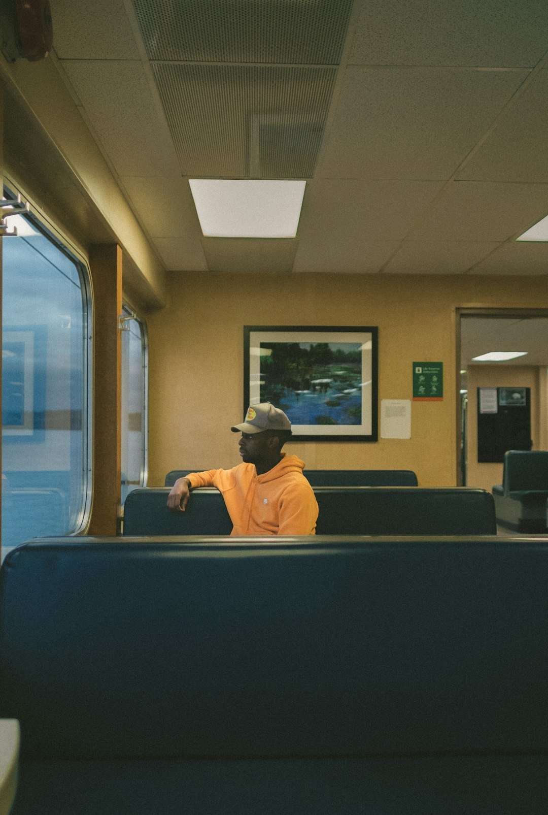 a man in an orange shirt is sitting on a train