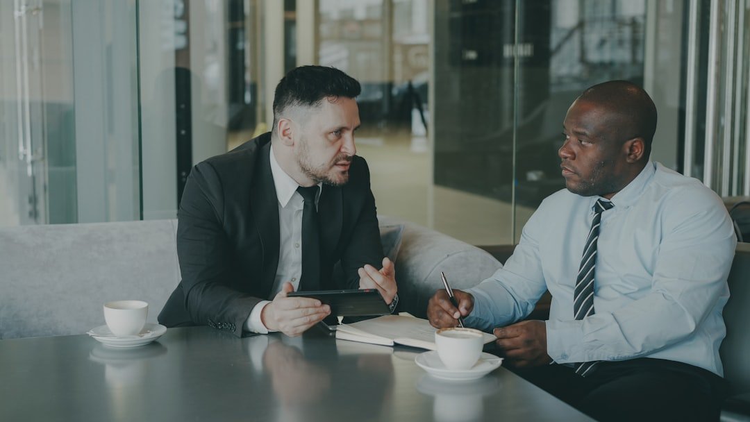 Two businessmen discussing work over coffee.