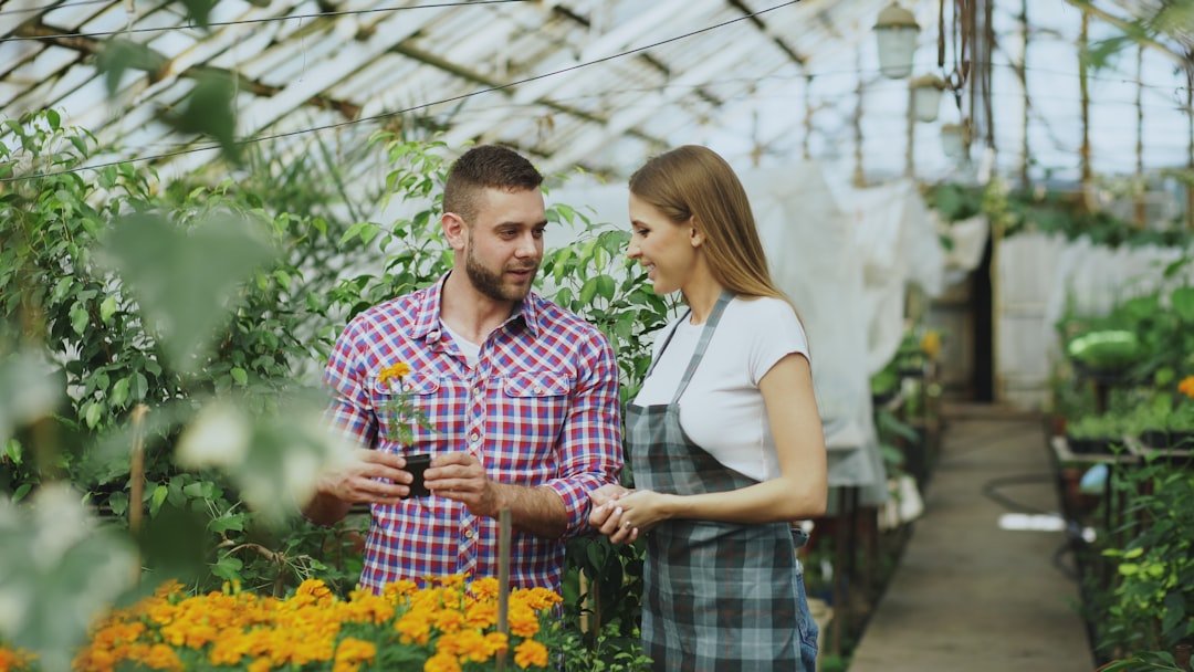 Man and woman discussing plants in a greenhouse.
