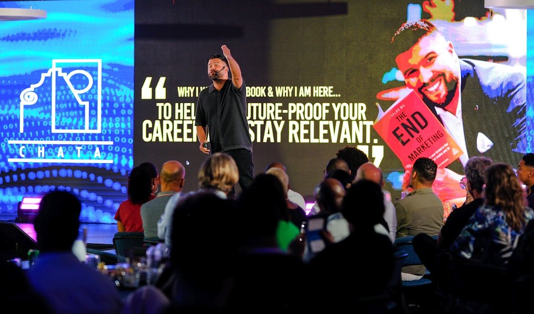 Speaker presents book to audience on stage