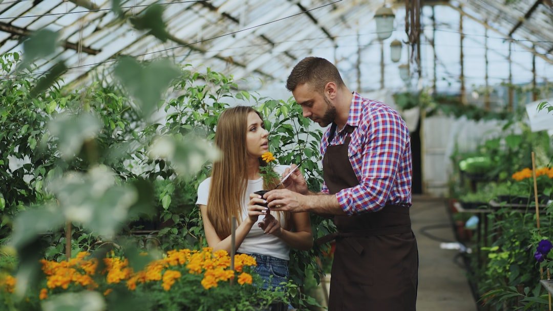 Couple examining flowers in a greenhouse