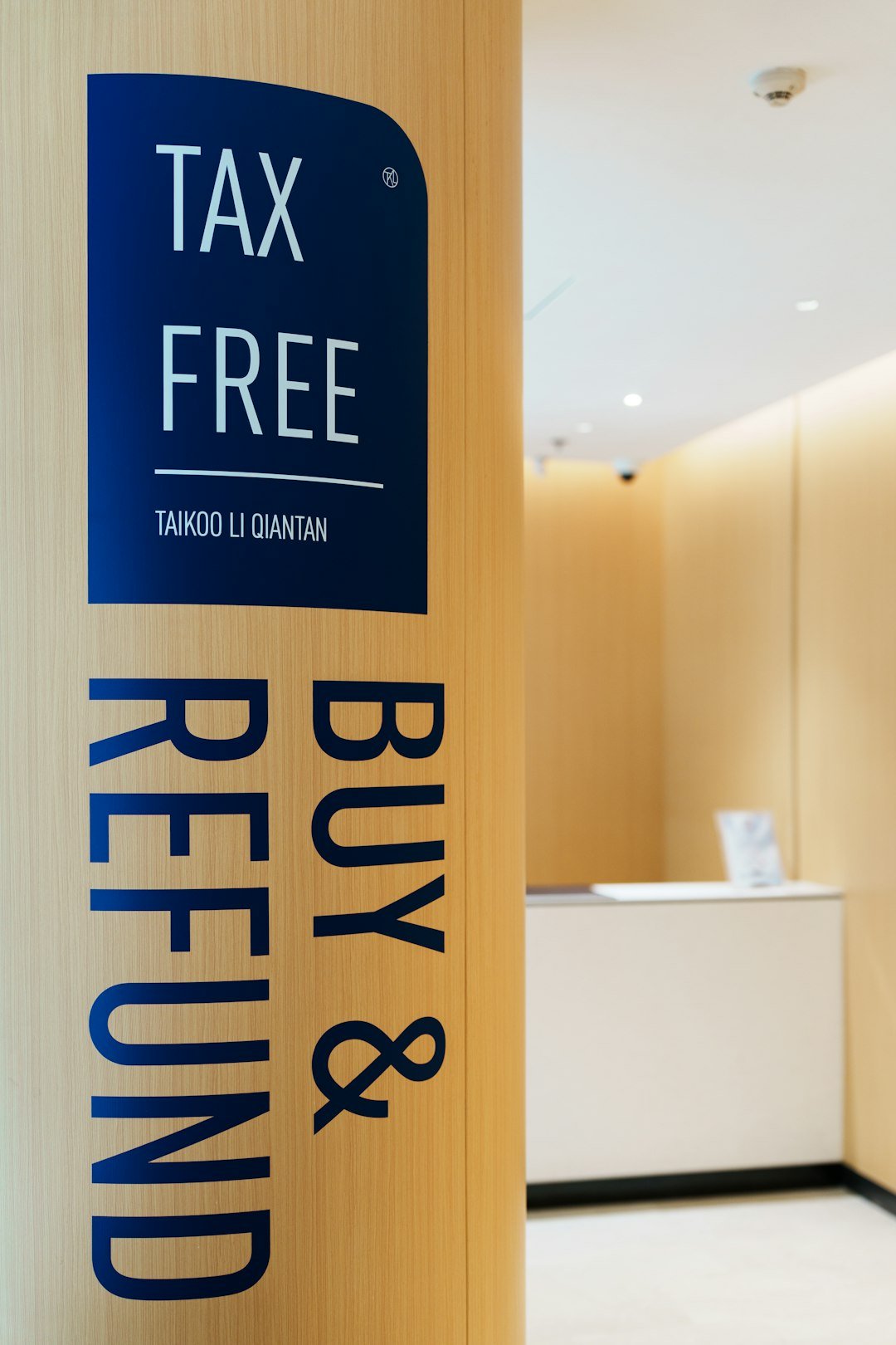 Tax free buy & refund sign on wooden pillar.