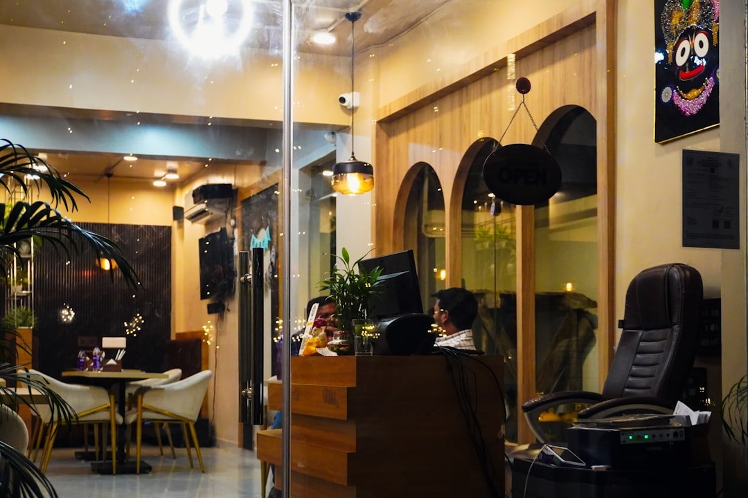 People working at a reception desk in a modern cafe.