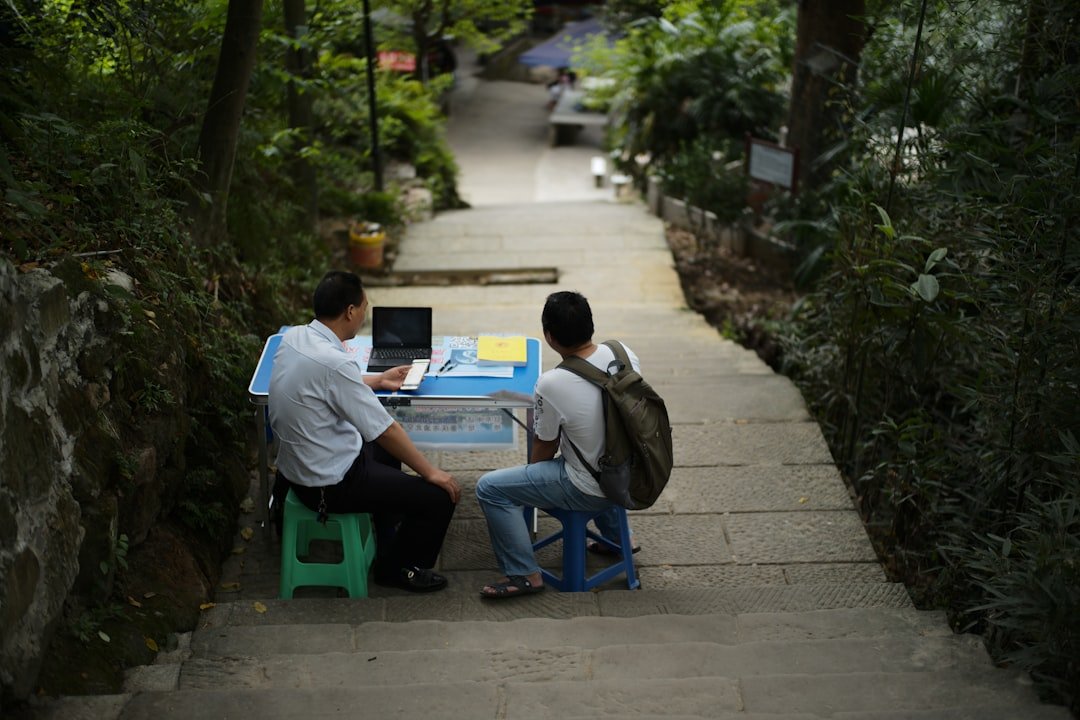 Two men at a table on a stone path