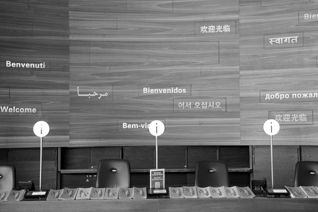 Welcome signs in multiple languages on wooden wall.