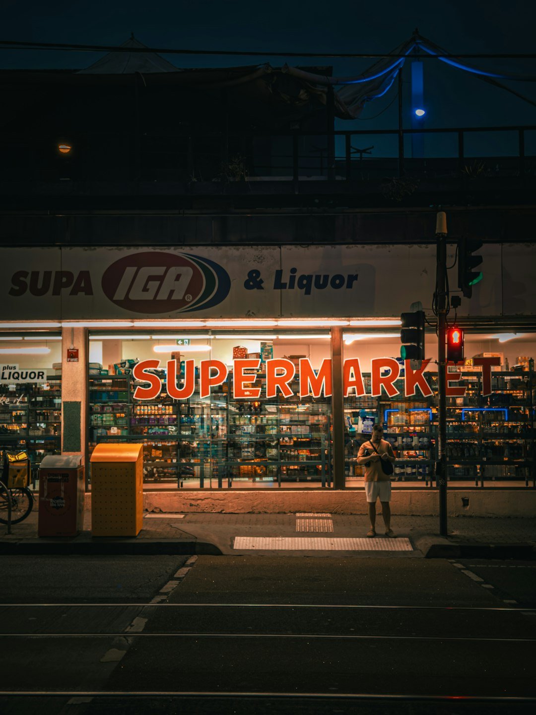 A supermarket brightly glows at night.