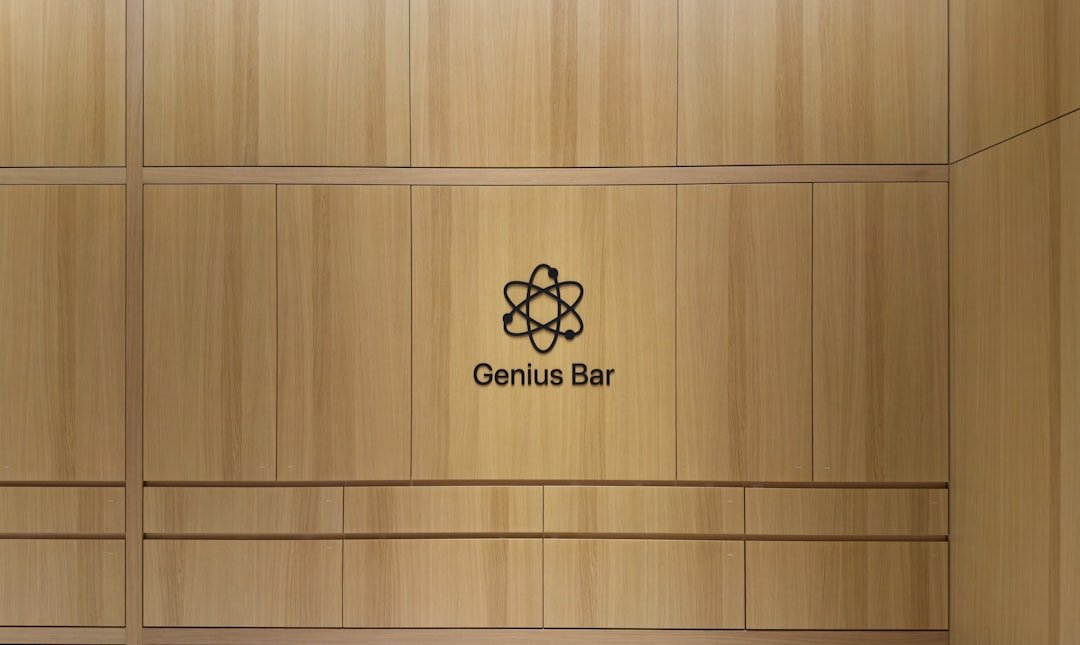 Genius bar logo on a light wood paneled wall