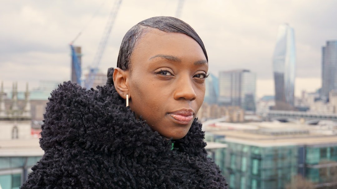 a woman in a black coat looking at the camera