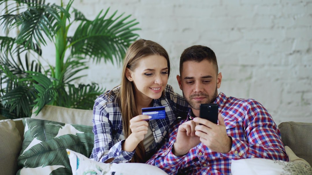 Couple happily shopping online with credit card and phone.