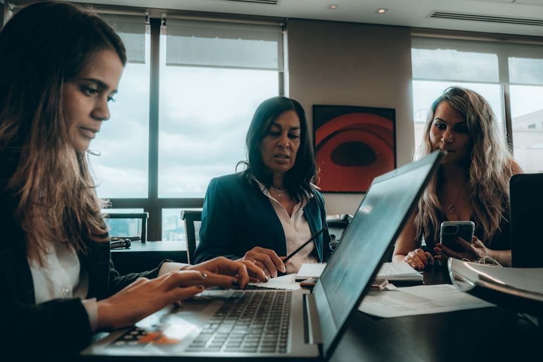 a group of women sitting around a laptop computer