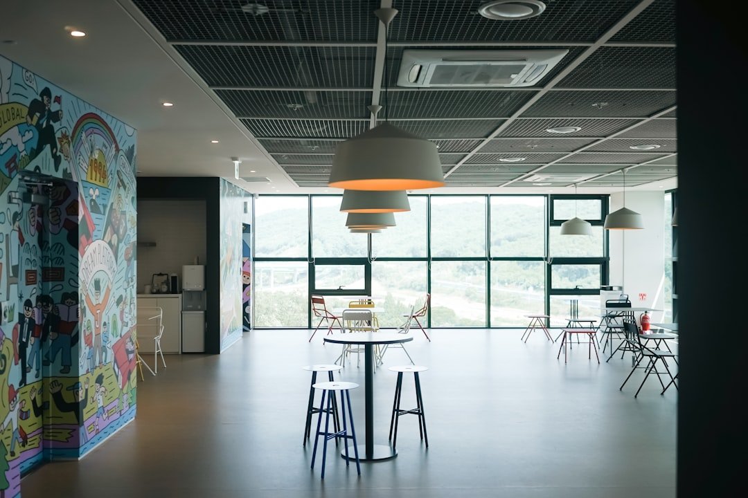 a room with a table, chairs, and a mural on the wall