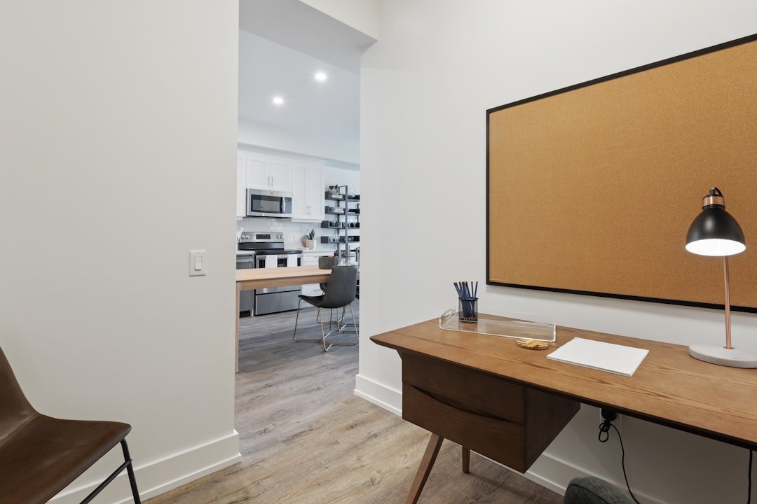 brown wooden table near white wall